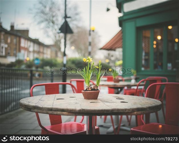 A table decorated with lillies outside a cafe in the street on a winter's day