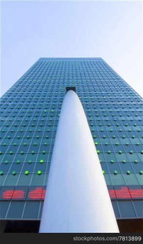 A tall and imposing corporate office building with a lightshow on the facade, and a huge supporting beam seen from below with a centered perspective