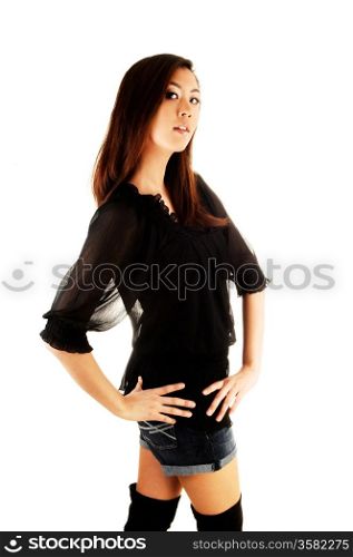 A tall and pretty chinese woman in a black blouse and long black bootsstanding in the studio for white background.