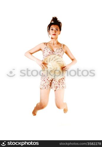 A tall and pretty young chinese woman in a summer dress, holding astraw hat on her stomach, jumping for white background.