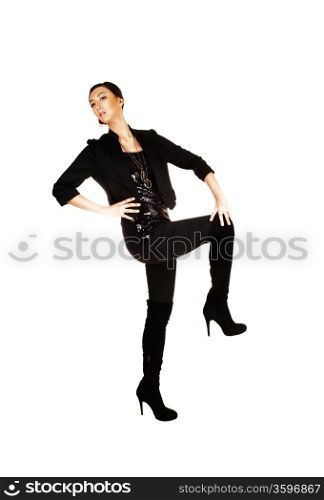 A tall and slim young chinese businesswoman standing in black tights and boots and blouse with a black light jacket for white background in the studio.