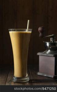A tall Glass of Cold Coffee a  coffee drink with coffee bean grinder