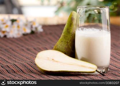 A tall glass of pear smoothie in a natural setting