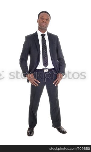 A tall handsome African American man standing in a dark suit nad tiewith his thump?s in his poket, isolated foe white background