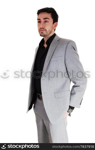 A tall handsome businessman standing isolated for white background in a grey suit with his hands in his pocket.