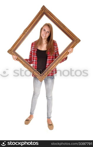 A tall pretty woman holding a picture frame for her upperbody, in jeans and a checkered shirt, over white.