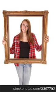 A tall pretty woman holding a picture frame for her upperbody, in jeans and a checkered shirt, over white.