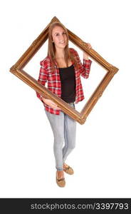 A tall pretty woman holding a picture frame for her upperbody, in jeans and a checkered shirt, over white.