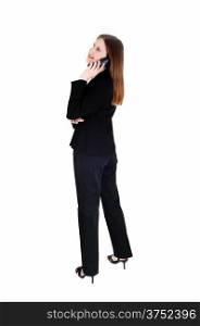 A tall slim young business woman standing in a black suit in profile,talking on the phone for white background.