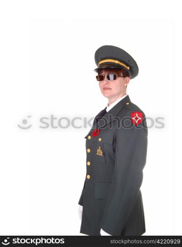 A tall woman in an military uniform and sunglasses standing in thestudio with white cloves for white background.