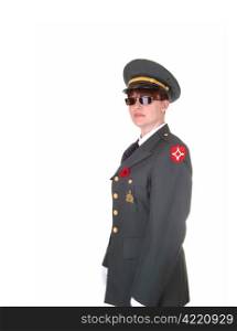A tall woman in an military uniform and sunglasses standing in thestudio with white cloves for white background.
