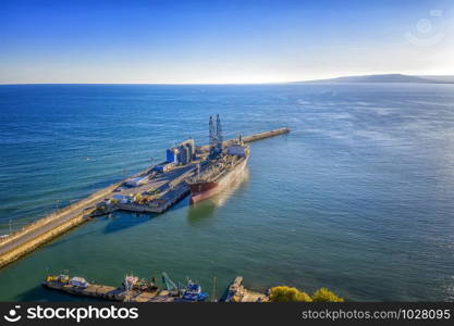A tanker of the city port. Aerial view from a drone. Concept export ship