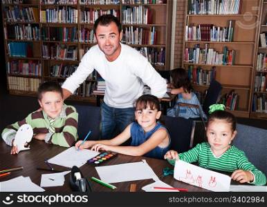 A teacher guides his students in an art class in the school library.