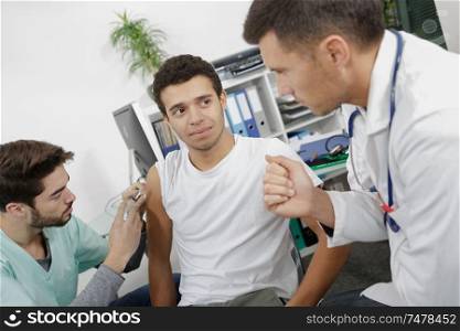 a team of doctors injecting a patient