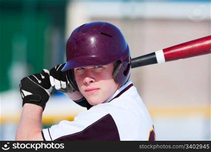 A teenage baseball player ready to bat.