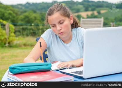 a teenage girl doing her homework in the garden
