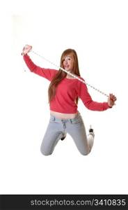 A teenage girl kneeling on the floor in jeans and a red sweater, holdinga measuring tape, whit long brunette hair for white background.