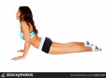 A teenage girl lying on the floor doing exercise, wearing black shorts,isolated on white background.
