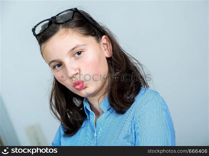 a teenage girl with glasses and a blue shirt