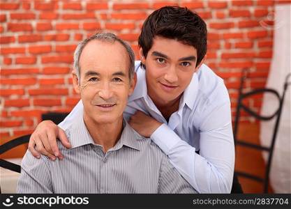 a teenager and his grandfather posing in a restaurant