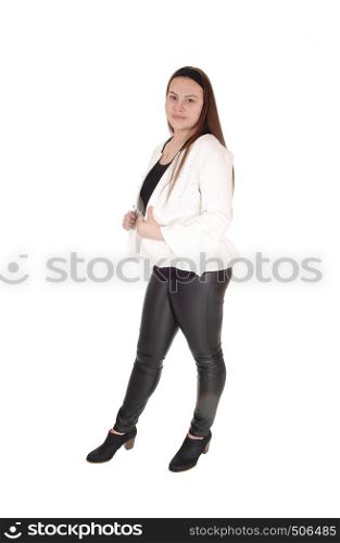 A teenager girl standing in black leather pants and a white jacket in profile, looking into the camera, isolated for white background