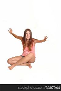 A teenager, sitting on the floor in the studio, is exited and having funin front of the camera, in bare feet for white background.