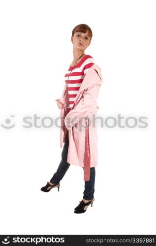 A teenager standing in a pink coat and jeans in the studio, lookingat the camera, for white background.