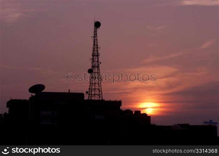 A telecom tower against a tropical sunset. Modern versus nature