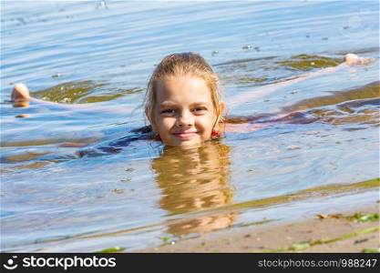 A ten-year-old girl lies in the water near the river