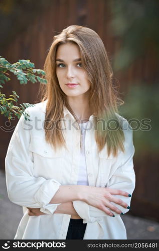 A tender portrait of a young girl in the sunset rays.. Cozy street portrait of a young beautiful girl 3689.