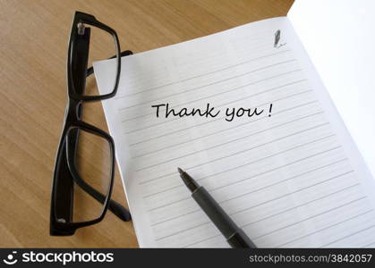 A thank you car with glasses on a wooden desk Writing a Thank You Note