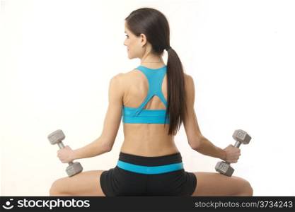 A thin healthy brunette woman in action weight trainig exercise