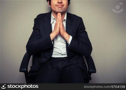 A thoughtful young businessman is sitting in an office chair