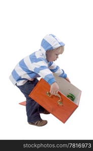 A three years old boy lifting a wooden toybox