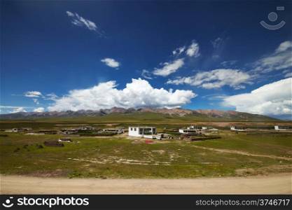 A Tibetan rural village in the outskirts. Mountain landscape with cloudy sky