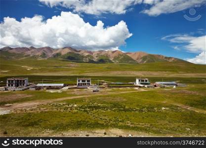 A Tibetan rural village in the outskirts. Mountain landscape with cloudy sky