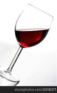 A tilted glass of red wine