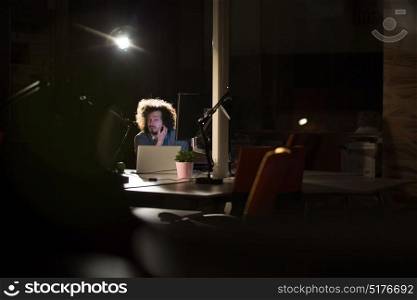 A time for relax. Young tired casual businessman relaxing at the desk in his night office