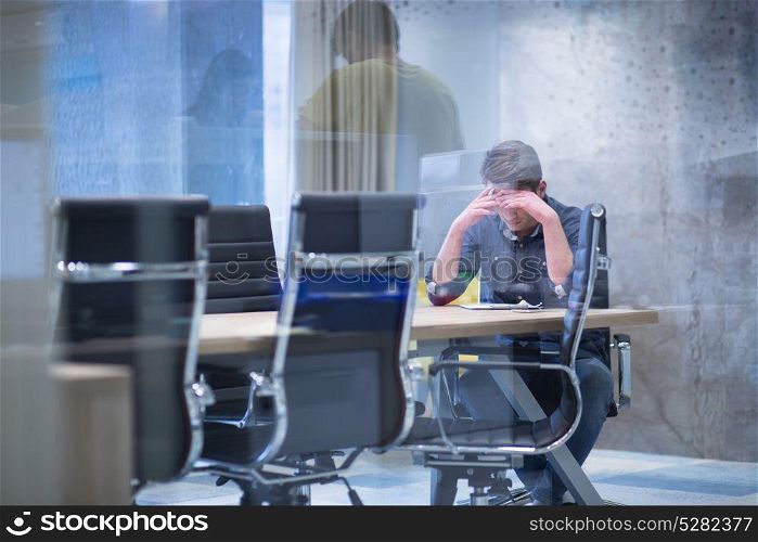 A time for relax. Young tired casual businessman relaxing at the desk in his office