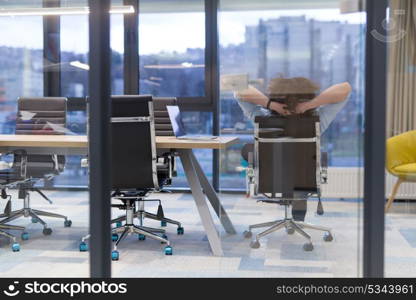 A time for relax. Young tired casual businessman relaxing at the desk in his office