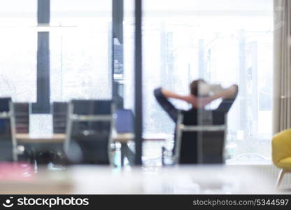 A time for relax. Young tired casual businessman relaxing at the desk in his office