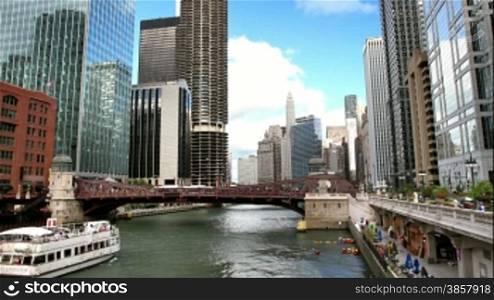 A time lapse of the Chicago River, surrounded by skyscrapers, with boats passing by