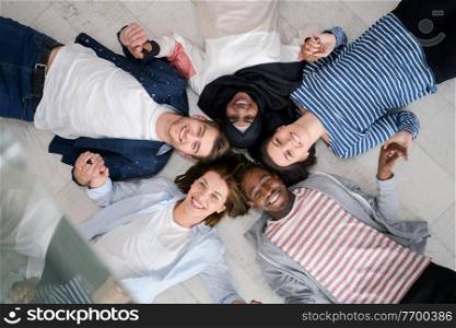 a top view of a diverse group of people lying on the floor and symbolizing togetherness
