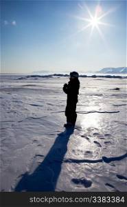 A tourist on a frozen ladscape, Spitsbergen, Svalbard, Norway