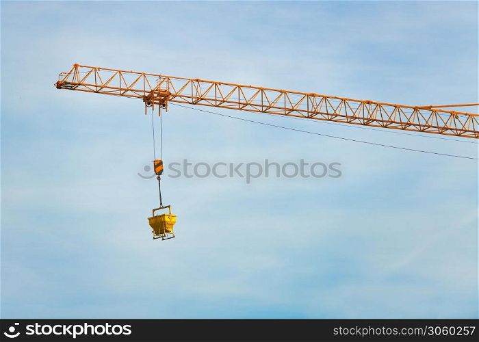 A tower crane in action in the sky of a building site.