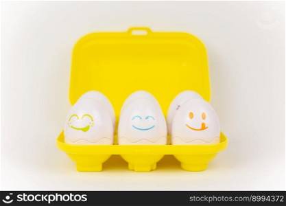 a toy plastic eggs in a yellow case on a white background. toy plastic eggs in a yellow case on a white background