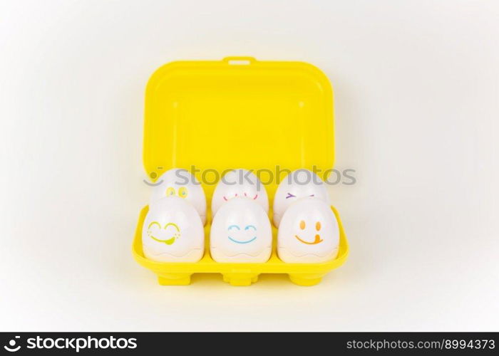 a toy plastic eggs in a yellow case on a white background. toy plastic eggs in a yellow case on a white background