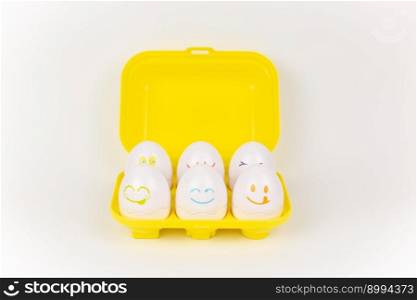a toy plastic eggs in a yellow case on a white background. toy plastic eggs in a yellow case on a white background