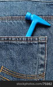 A toy plastic hammer in a back pocket of a denim
