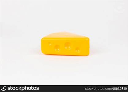 a toy plastic piece of masdam cheese on a white background. toy plastic piece of masdam cheese on a white background